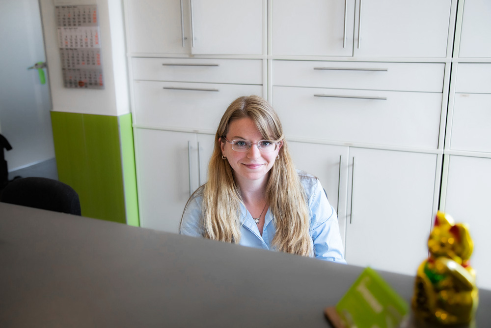 Freundliche Mitarbeiterin am Empfang begrüßt Patienten